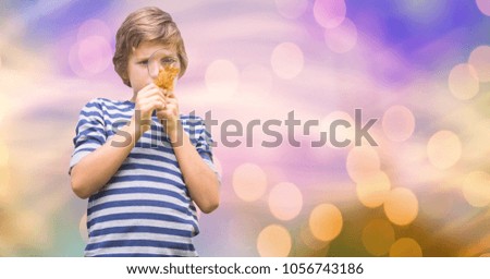 Digital composite of Boy looking at autumn leaf through magnifying glass