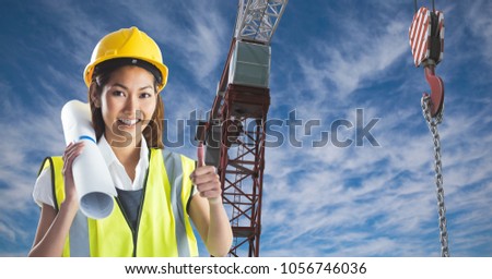 Digital composite of Female architect showing thumbs up against crane