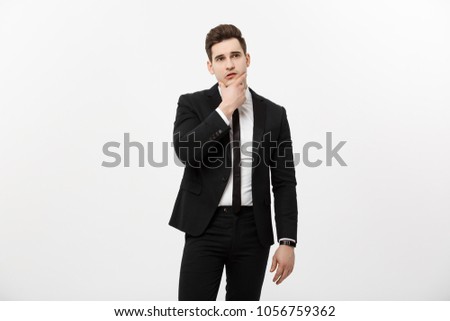 Business Concept: Young handsome man in black suit looking at copy-space smiling, thinking or dreaming
