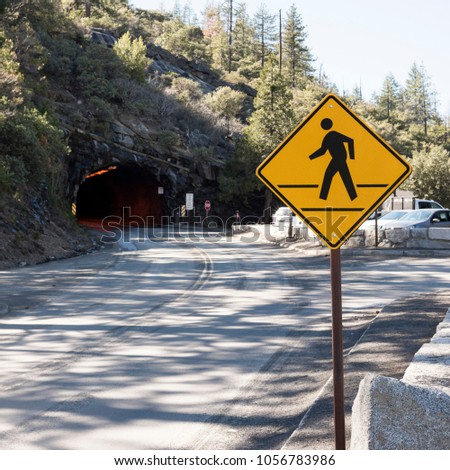 Caution sign that people pass, coming out of a tunnel