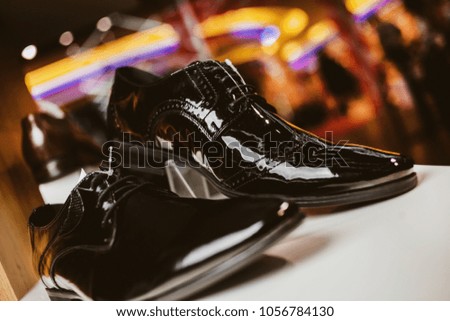 Stylish leather / lacquered men's shoes on the shelf in the store. Black / brown men's shoes on the stand. Male style, fashion. Gatherings of the groom. vintage photo processing