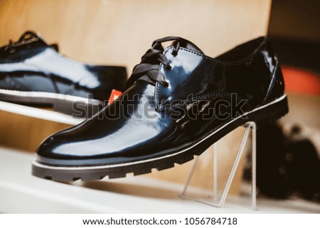 Stylish leather / lacquered women's shoes on the shelf in the store. Black / dark blue women's shoes on the stand. Female style, fashion. vintage photo processing