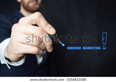 The businessman writes a blue marker inscription:INBOUND MARKETING