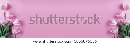 Pink tulips flowers on pink background. Waiting for spring. Happy Easter card. Flat lay, top view Royalty-Free Stock Photo #1056875555