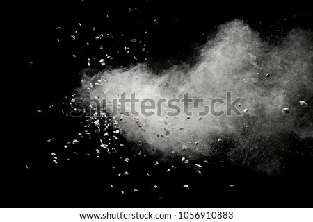 White powder with small stones isolated on black background. Small granite rock stone fly on dust against dark background. Royalty-Free Stock Photo #1056910883