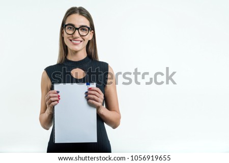 Positive smiling businesswoman in glasses black dress showing a clean white document with copy space. White background.
