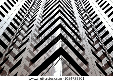 Perspective abstract view of geometric patterns and reflections on the glass and stone exterior of a modern office building