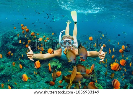 Happy family - girl in snorkeling mask dive underwater with tropical fishes in coral reef sea pool. Travel lifestyle, water sport outdoor adventure, swimming lessons on summer beach holiday with kids Royalty-Free Stock Photo #1056933149