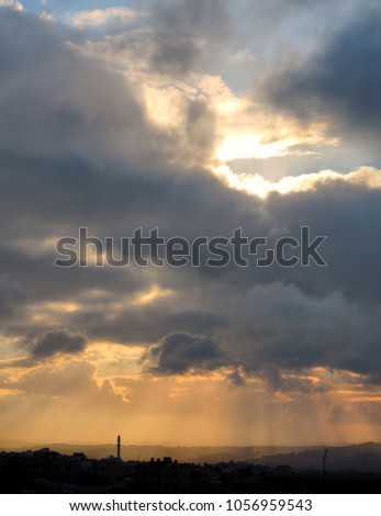 A beautiful Silhouette of the Amman skyline with sunrays peeping through the clouds in the early morning 