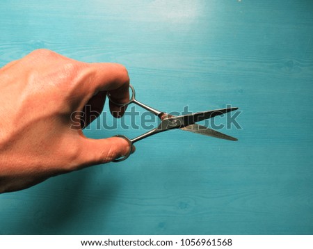 A picture of the scissors being put in  fingers and tried to cut.