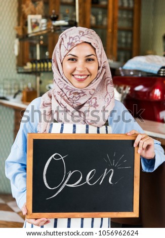 Arabic woman standing with open board sign