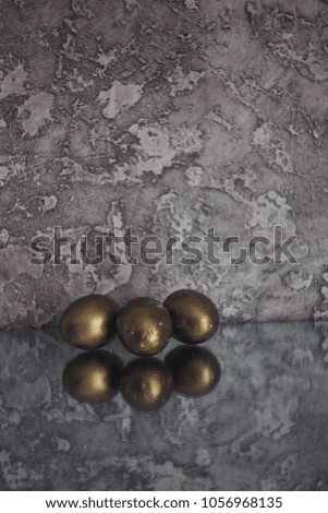 Easter photo of golden eggs in a wooden box on a gray background. white easter eggs. on a green cloth. with flowers. Chrysanthemum chamomile.