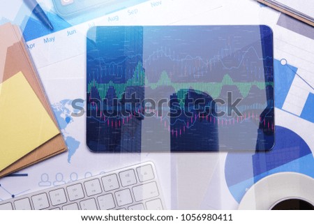 Top view of tablet with business chart on screen placed on office desktop with various items. Fund management and money concept. Double exposure 