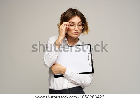   business woman in a white shirt holding a folder-tablet with documents                             