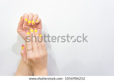 picture of fashionable beautiful woman hand painting colorful cute pink yellow flower gel acrylic artificial nail art design on finger isolate on bright white background with copy space for text