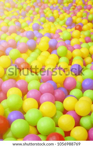 Many colorful plastic balls in a kids' ballpit at a playground. Close up pattern