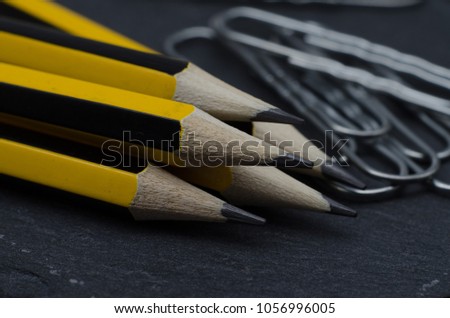 Pencils and paper clips on the stone background. Macro.