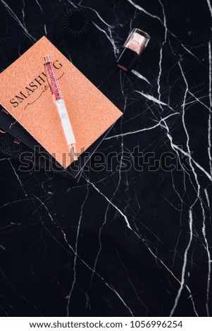 Rose golden glitter notepads with glamorous pen on black marble table. Copy space for text. Minimalism fashion, beauty blogging, freelancing concept. 
