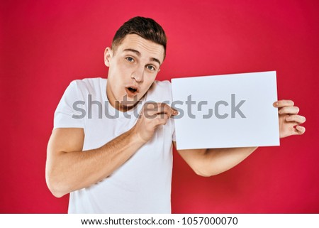    surprised man holding a sheet of paper, copy place                            