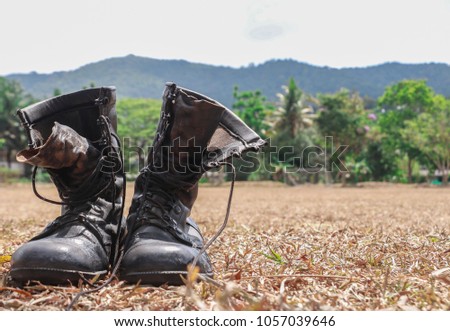 Old military boots Lay on a grass field