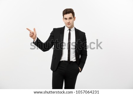 Business Concept: Close up portrait of young successful brunete stock-market broker guy or businessman pointing on a copyspace with his finger on white background.
