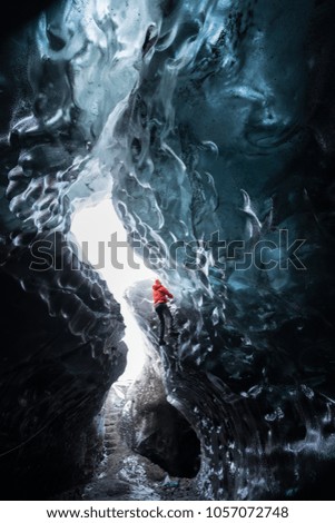 Man wear red coated hiking the ice wall to get to the top / Adventure concept / outdoor activity / Sport concept