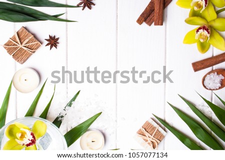 Flat lay with leaves of palm trees and objects for spa on a white wooden background