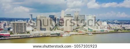 Panorama aerial view riverside downtown New Orleans, Louisiana, USA.  Top view Central Business District (CBD), a Mississippi neighborhood. Skyscrapers and modern office towers under cloud blue sky