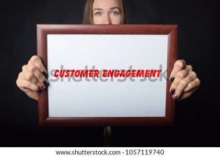 In the hands of a businessman a frame with the inscription:CUSTOMER ENGAGEMENT