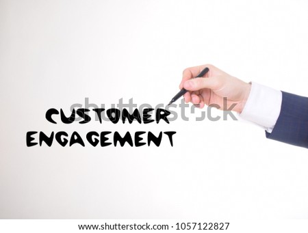 The businessman writes a black marker inscription:CUSTOMER ENGAGEMENT