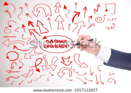 The businessman writes a red marker inscription:CUSTOMER ENGAGEMENT