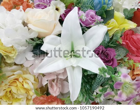 Close-up of fabric white lily flower in colorful background.