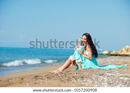 happy family in a blue dress. Mother with baby on the beach