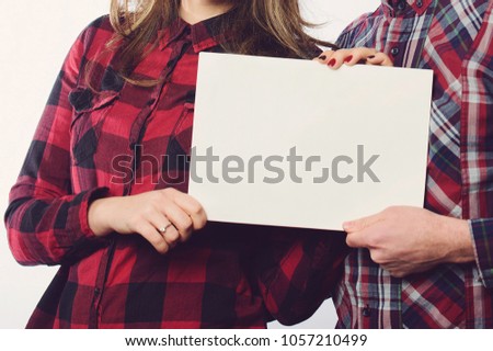 couple holding white blank sheet of paper