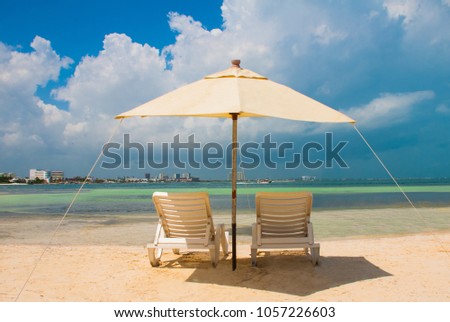 Sun umbrella and beach beds on tropical sandy beach, Tropical destinations. Cancun, Mexico. Mexico Royalty-Free Stock Photo #1057226603