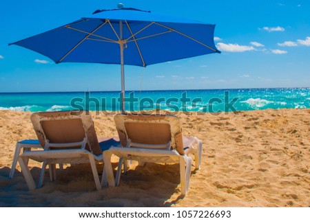 Sun umbrella and beach beds on tropical sandy beach, Tropical destinations. Cancun, Mexico. Mexico Royalty-Free Stock Photo #1057226693