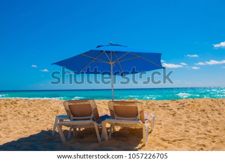 Sun umbrella and beach beds on tropical sandy beach, Tropical destinations. Cancun, Mexico. Mexico Royalty-Free Stock Photo #1057226705