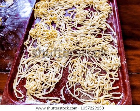 Pictured in the photo home-made noodles on a large brown tray.