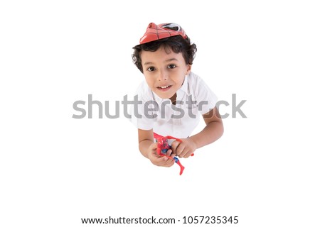 A little boy looking up, above shot wearing spiderman mask putting it on his head, isolated on a white background.