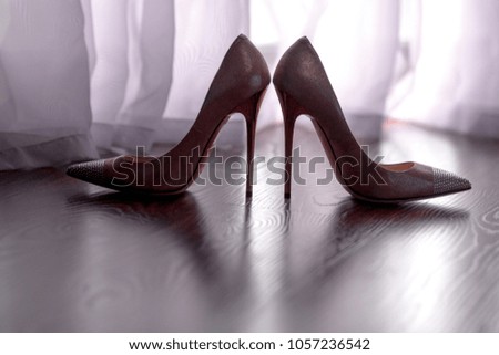 silhouette of high-heeled shoes on wooden floor. Wedding bride preparation