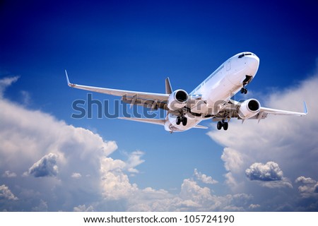 Boeing 737 jet aeroplane landing through gap in stormy sky. Royalty-Free Stock Photo #105724190