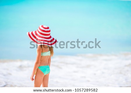 Cute little girl in hat at beach during caribbean vacation