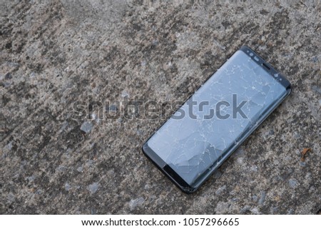 Smartphone with cracked screen on the floor