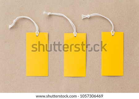 Three emtry yellow price tag on brown paper background 