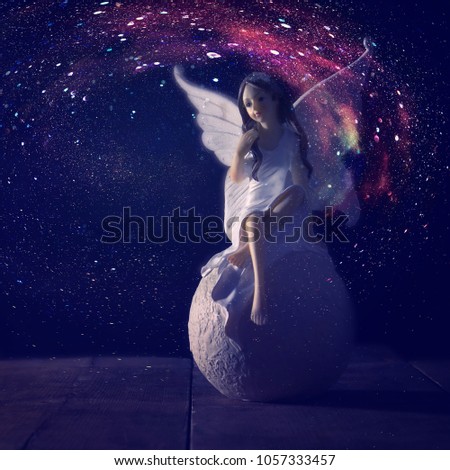 image of magical little fairy sitting over the stone