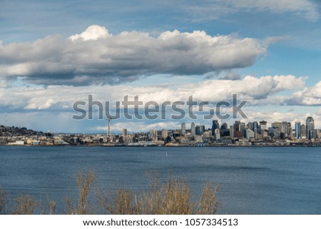 A view of the Seattle skyline with billowing clouds overhead.