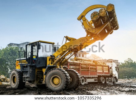 Forklift truck grabs wood in a wood processing plant Royalty-Free Stock Photo #1057335296