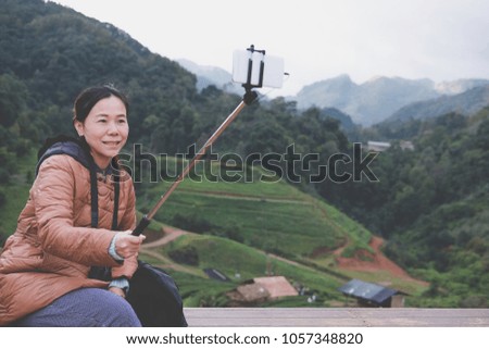 tourist use smart phone to take selfie photo with mountain view. people, travel, nature concept.