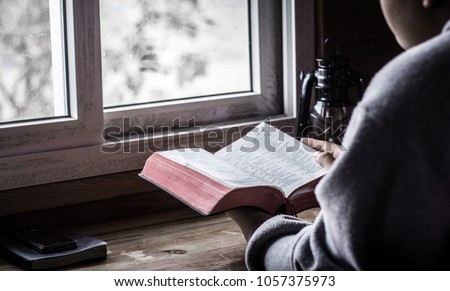 Young holding Bible book and reading