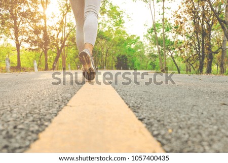 Ready for a sprint. Runner athlete standing on road towards sun. Concept of new start, travel, freedom etc. Close up cropped low angle photo of shoe of athlete.